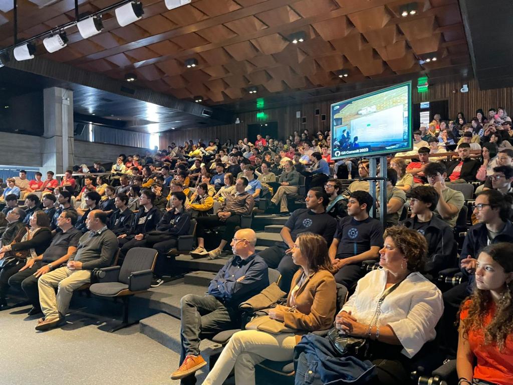 An auditorium with stadium-style seating filled with a rapt audience!