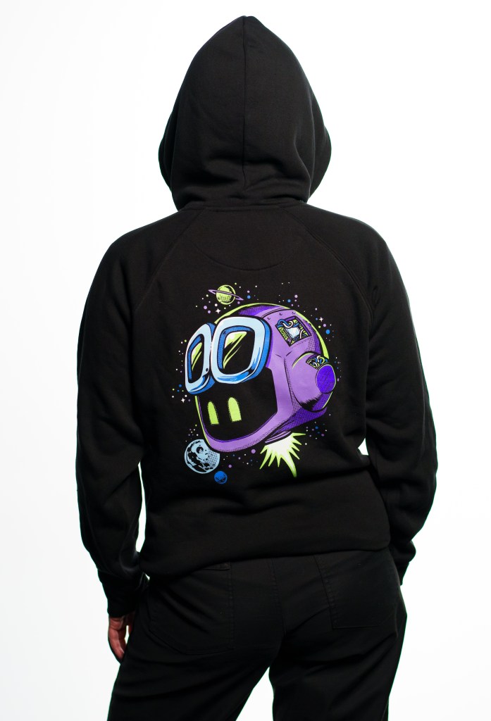 Person wearing a black hoodie facing away from the camera. On the back of the hoodie is a glow in the dark Copilot surrounded by stars and planets.